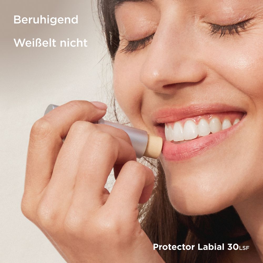 Frau trägt Lippenpflegestift auf. Silbernes Gehäuse, orangefarbener Deckel. ISDIN Protector Labial LSF 30.