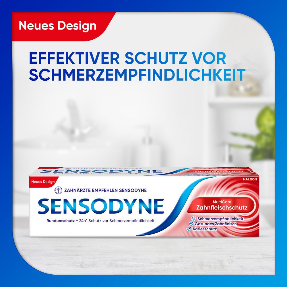 Zahnpasta-Verpackung. Weiß, blau und rot. Aufschrift: Sensodyne, MultiCare Zahnfleischschutz. Hintergrund: Badezimmer.