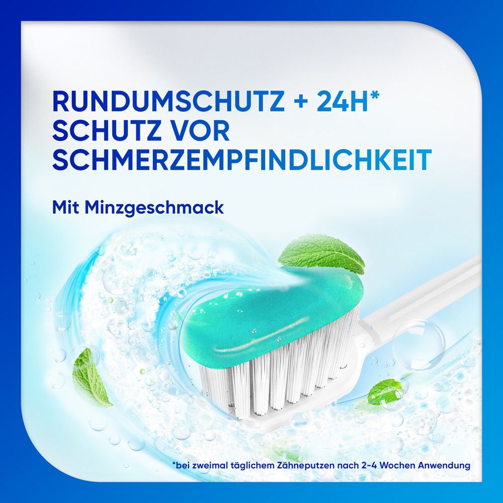 Zahnbürste mit Zahnpasta. Blaue Zahnpasta auf Bürste. Hintergrund: Wasser und Minzblätter.