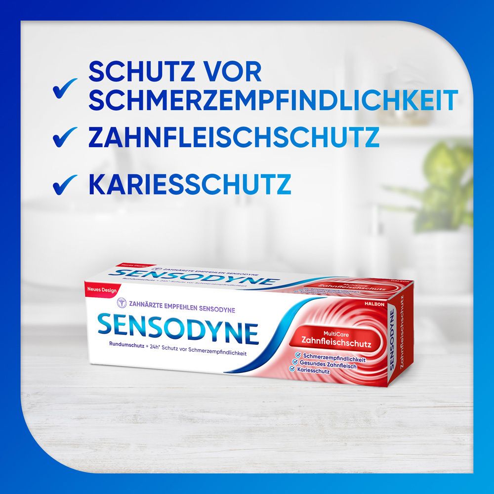 Zahnpasta-Verpackung. Weiß, blau und rot. Aufschrift: Sensodyne, MultiCare Zahnfleischschutz. Hintergrund: Badezimmer.