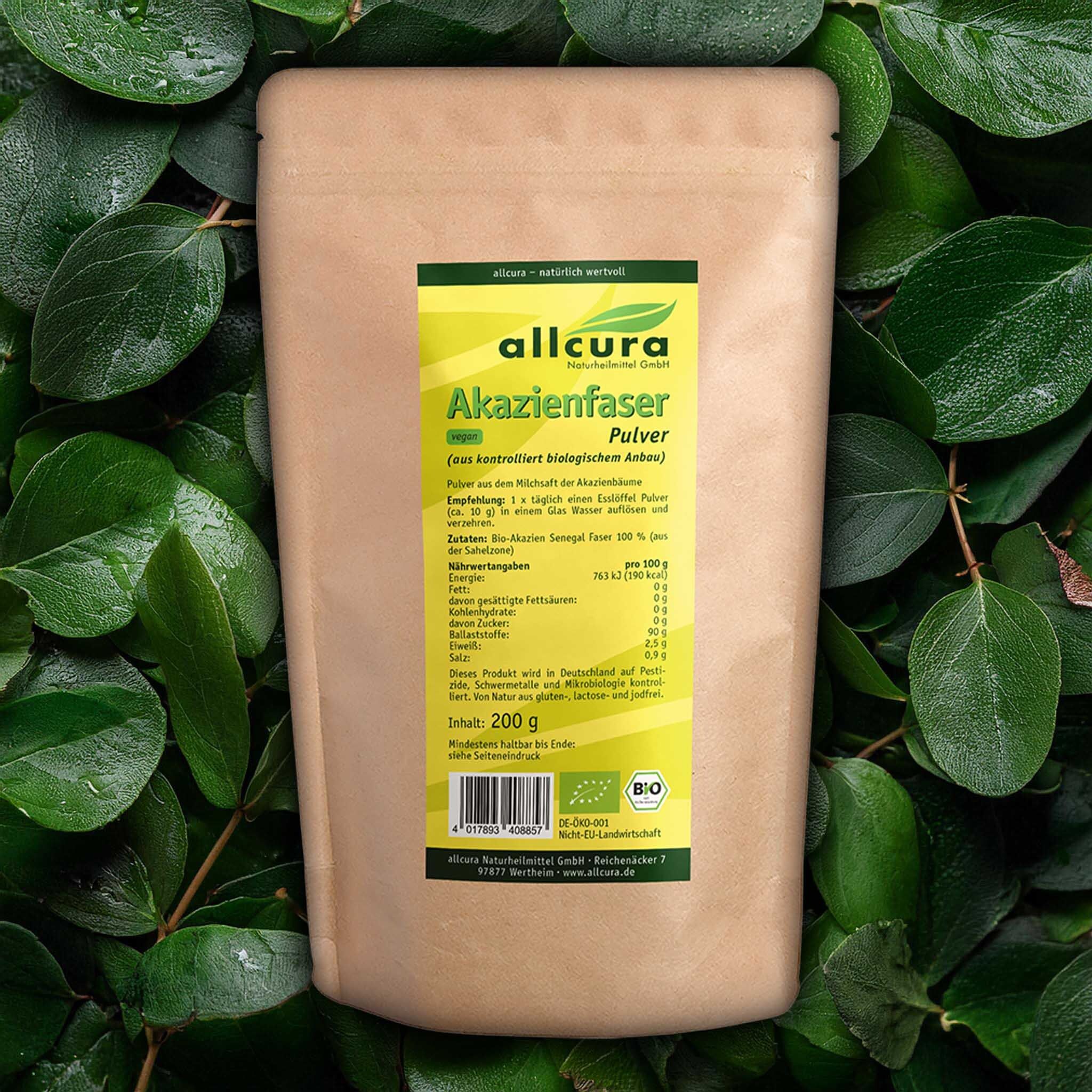 Produktverpackung mit Akazienfaser Pulver. Aufdruck mit Produktinformationen und Bio-Siegel. Umgeben von Blättern.