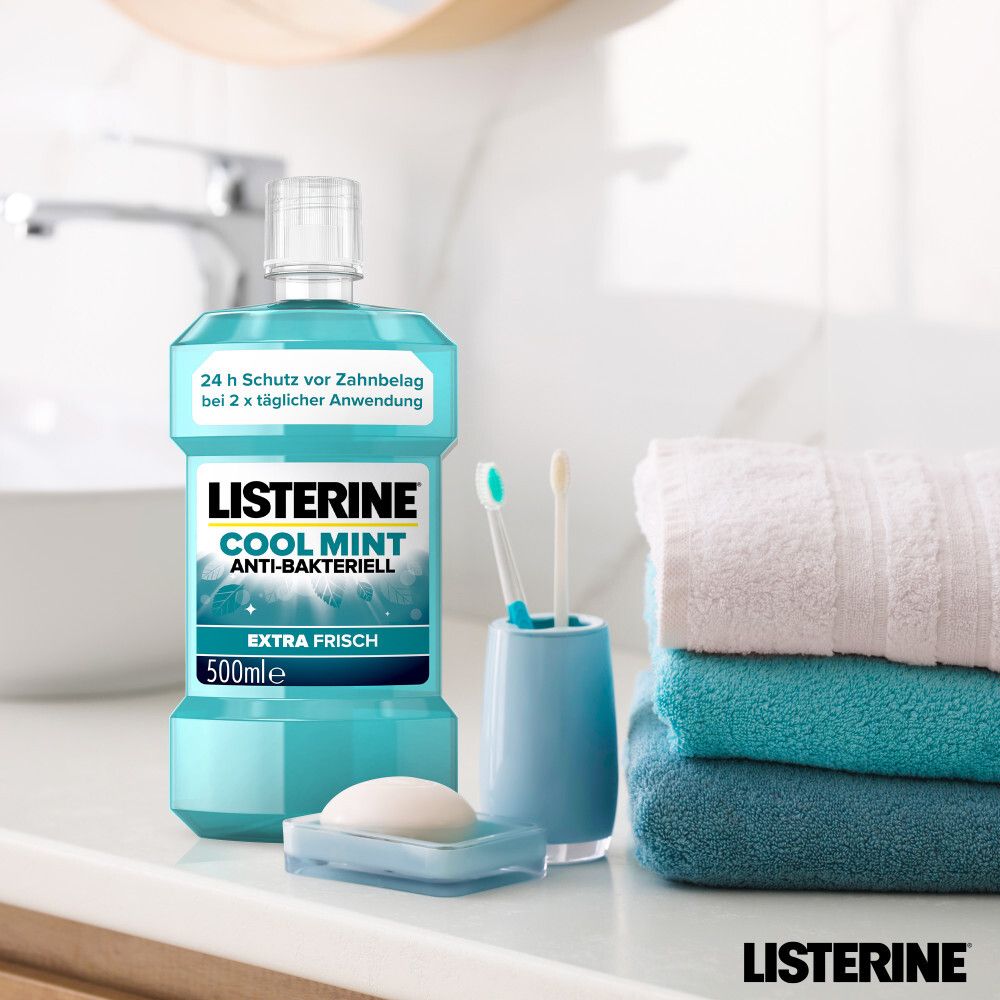LISTERINE® Cool Mint Flasche auf Waschbecken mit Zubehör: Zahnbürsten, Seife, Handtücher.