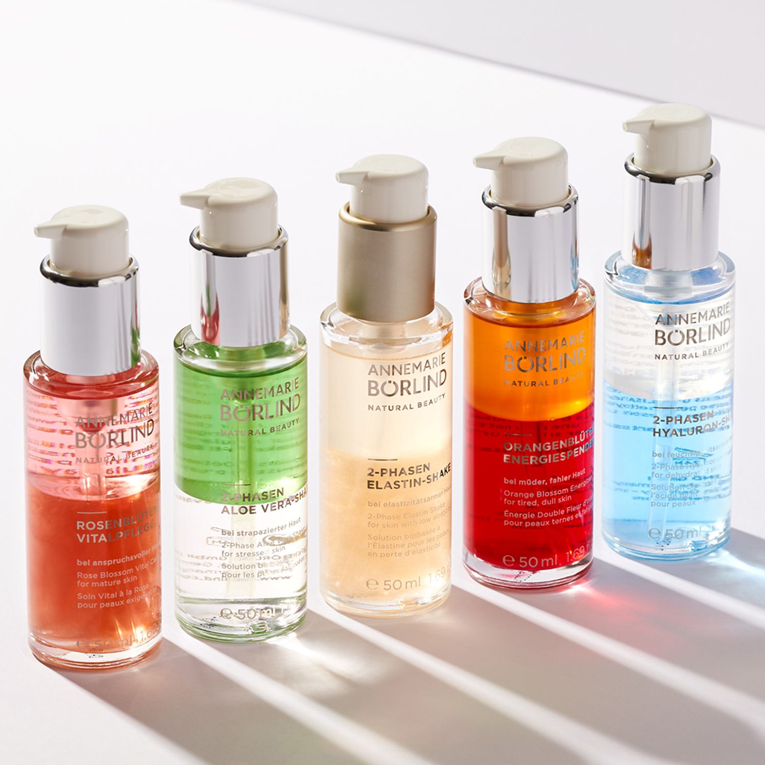 Fünf Flaschen. Verschiedene Farben. Text. ANNEMARIE BÖRLIND. 2-Phasen Elastin Shake. Rosi Vita. Hyaluron.