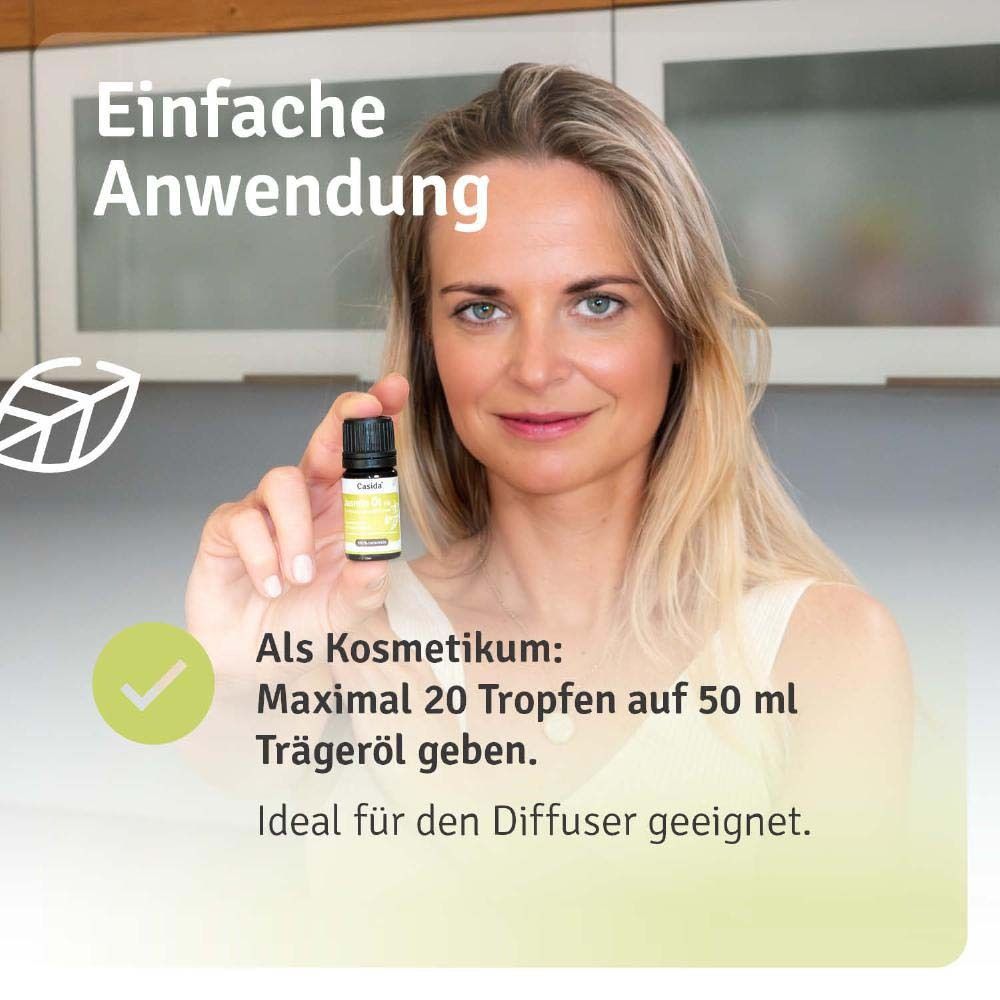 Frau hält Casida Jasmin Öl 5% Flasche. Anwendung: maximal 20 Tropfen auf 50 ml Trägeröl.