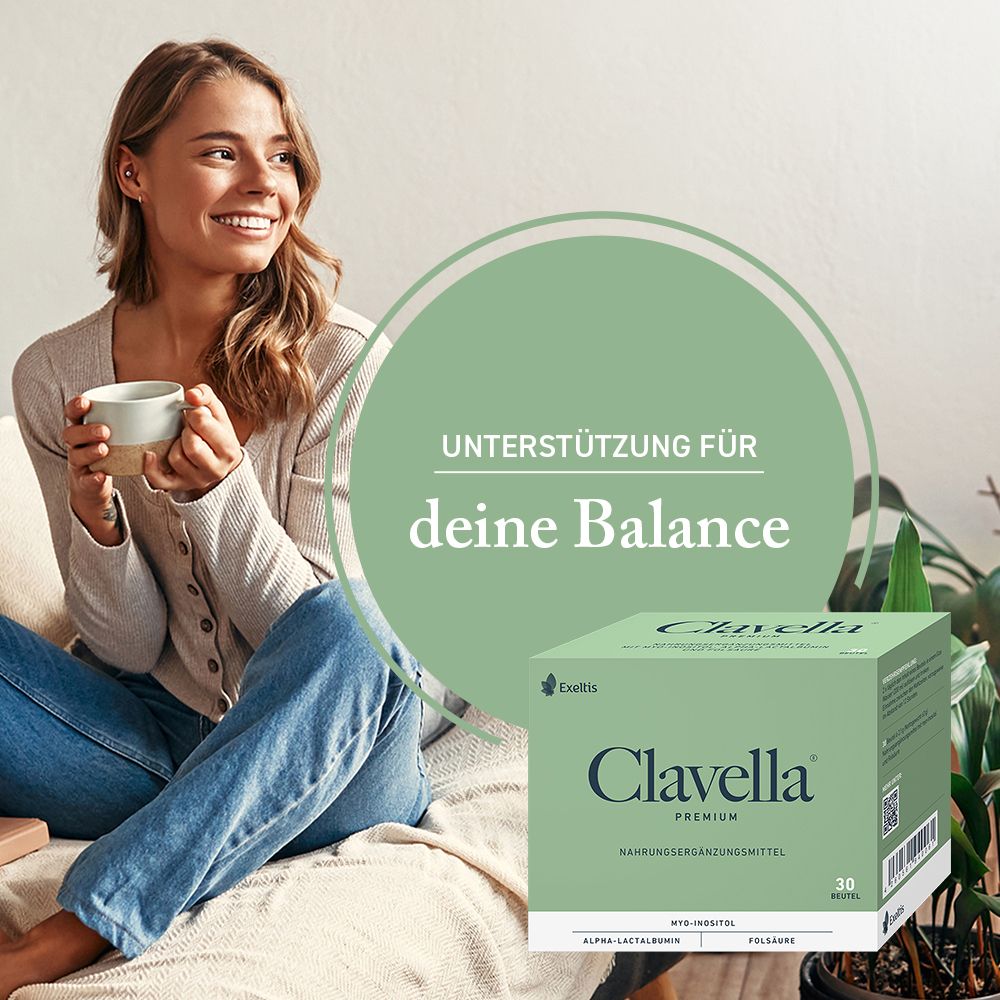 Frau sitzt entspannt mit einer Tasse, neben ihr die Clavella Premium Packung.