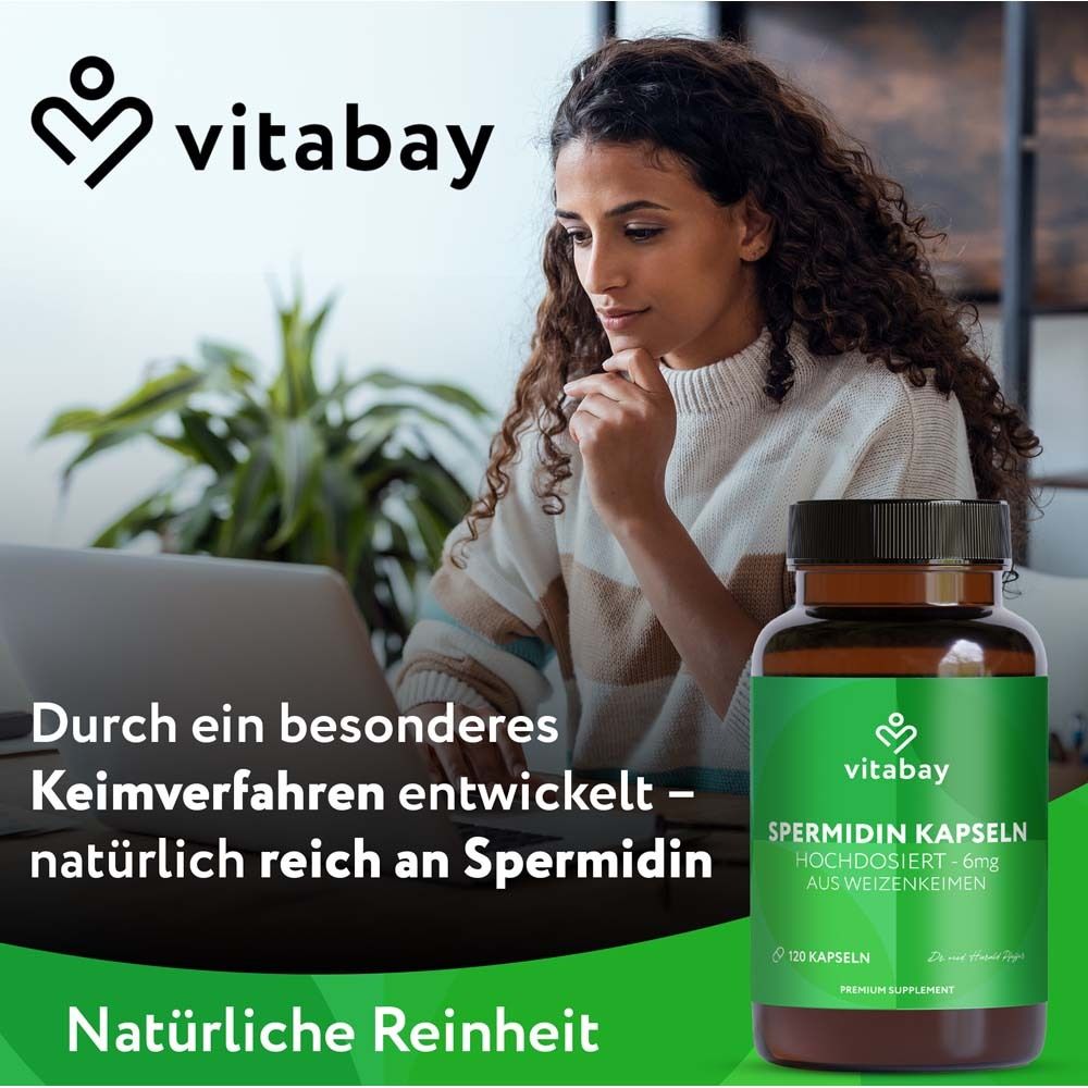Frau am Laptop neben einer Flasche Vitabay Spermidin Kapseln. Text: Natürliche Reinheit. Durch ein besonderes Keimverfahren entwickelt.