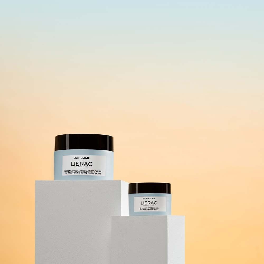 Zwei Creme-Tiegel auf Podesten. Aufschrift: Sunissime, LIERAC. Schwarze Deckel, blaue Etiketten. Unterschiedliche Größen.