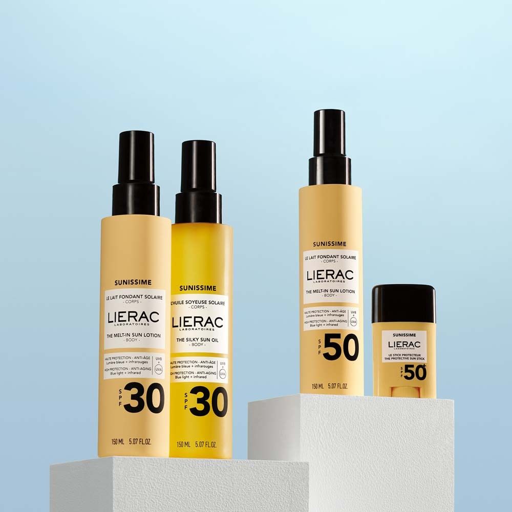 Drei Sonnenprodukte auf Podesten. Zwei Sonnenlotionen SPF30, eine Öl SPF30 und ein Stick SPF50. LIERAC-Logo sichtbar.