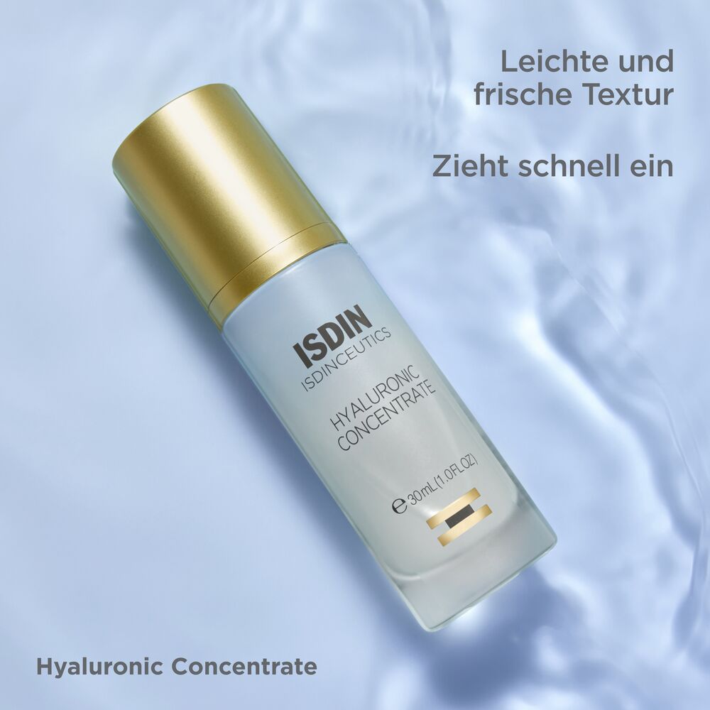 Isdin Hyaluronic Concentrate Serum auf einem blauen Hintergrund mit Wassertropfen.