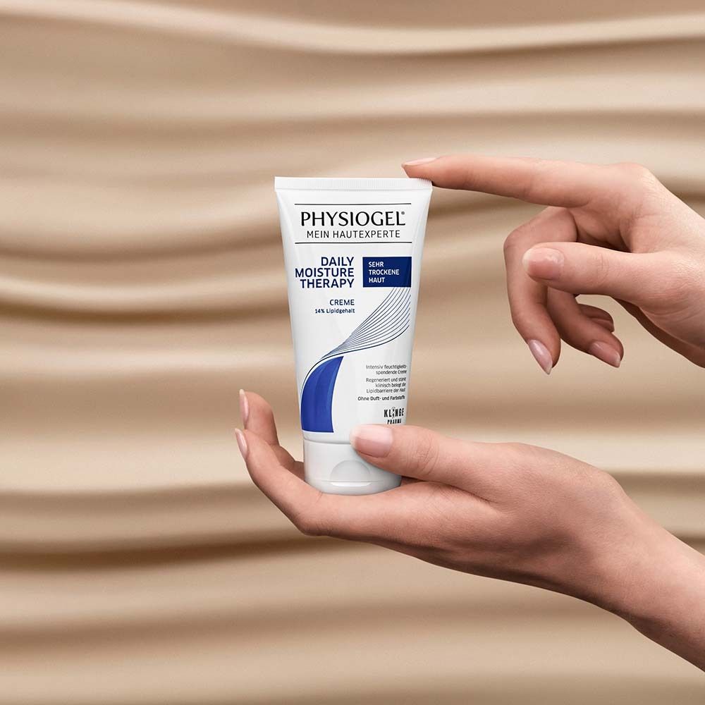 Hände halten PHYSIOGEL® Creme-Tube. Produkt im Fokus.