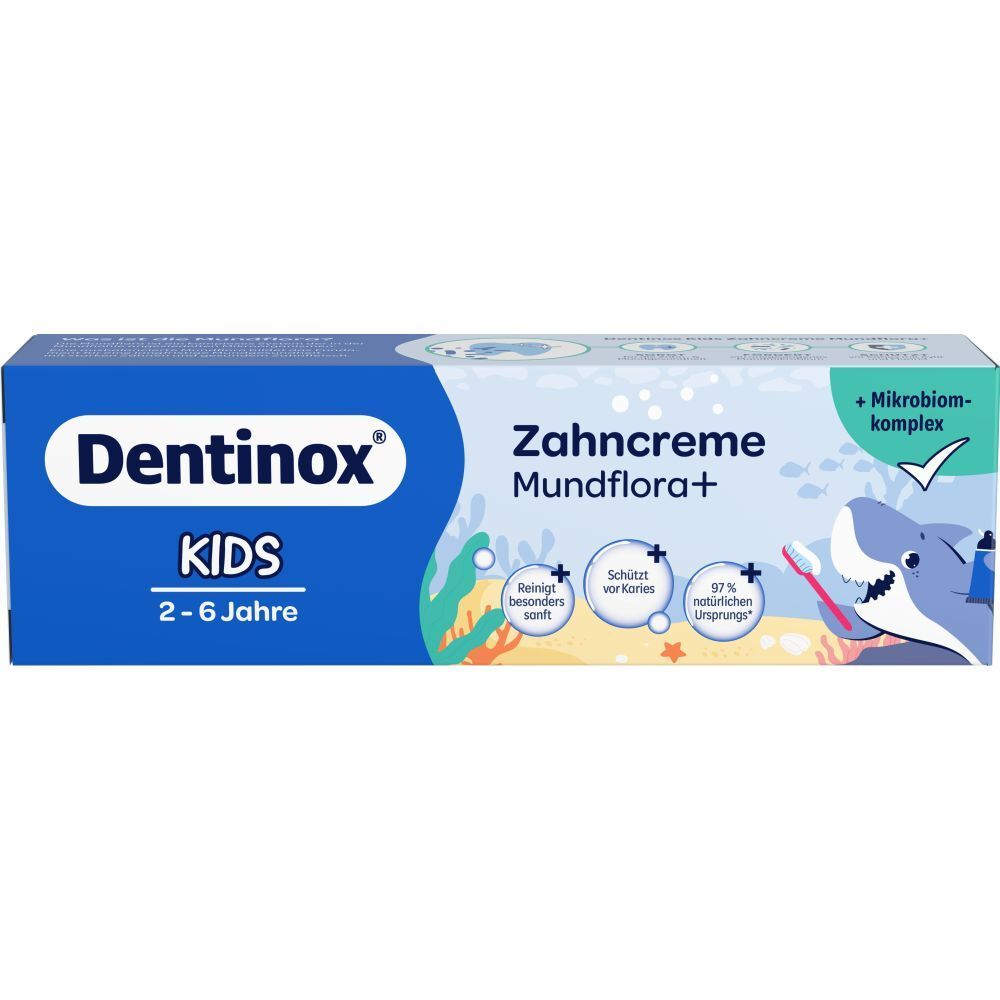 Zahncreme-Tube und -Karton. Blau, mit "Dentinox KIDS" und "Zahncreme Mundflora+". Enthält Illustrationen und Logos.