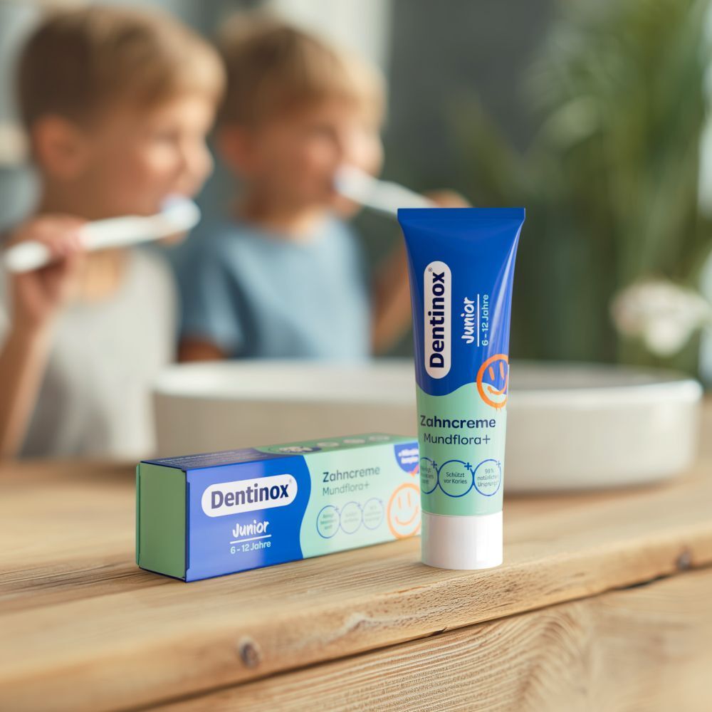Zahncreme-Tube und -Schachtel, Dentinox Junior, Mundflora+. Kinder putzen Zähne. 6-12 Jahre.