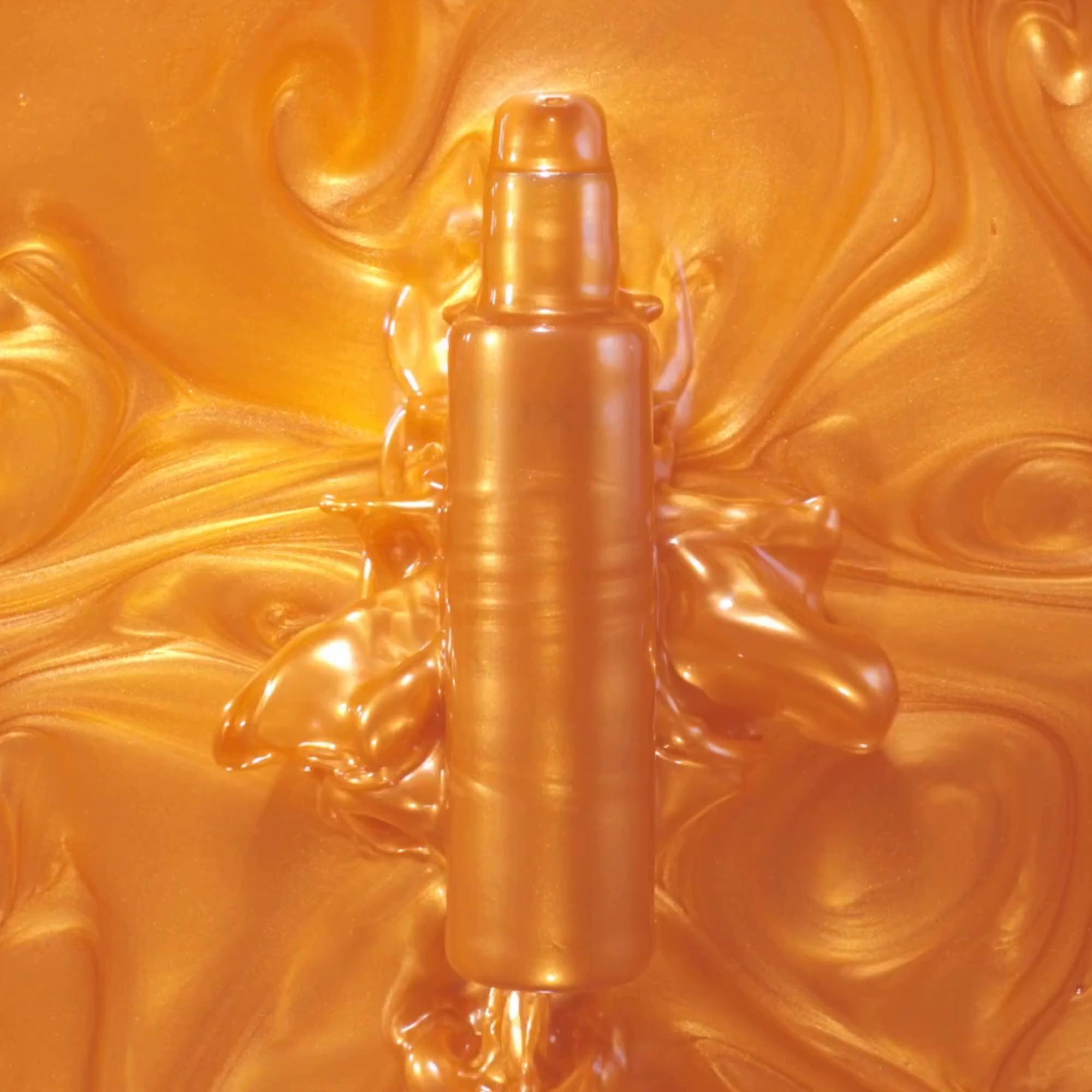 Goldfarbenes Öl mit Textur. Keine Flasche sichtbar.