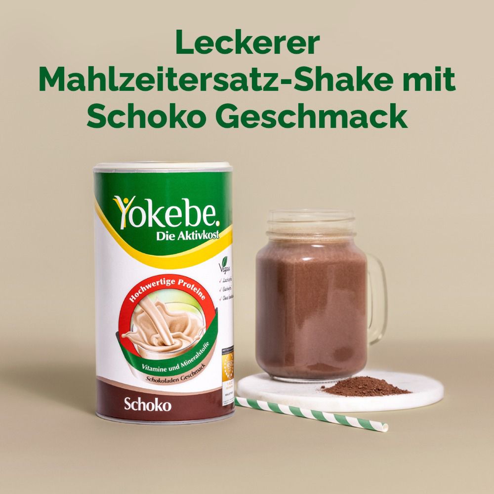 Yokebe Schoko-Shake in Glas mit Strohhalm. Dose und Pulver daneben. Leckerer Mahlzeitersatz-Shake.