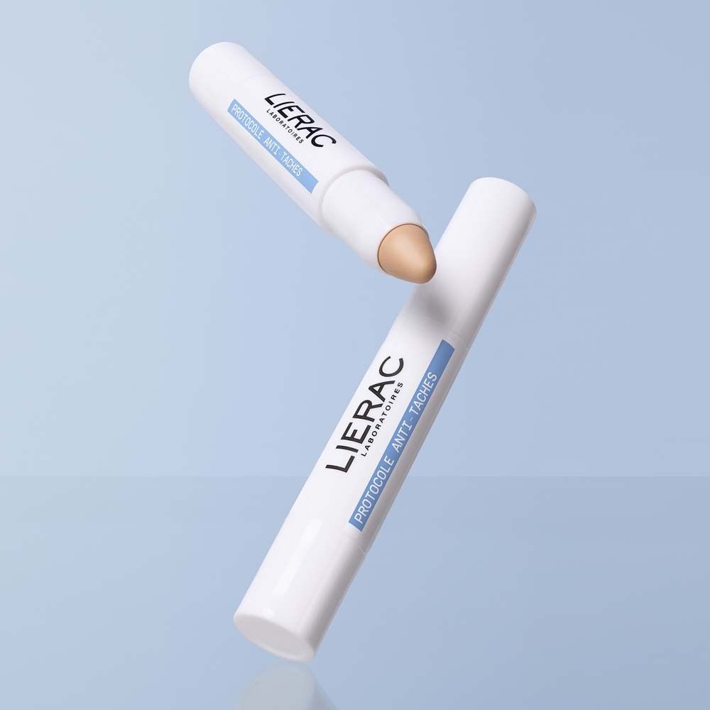 Zwei weiße Sticks. LIERAC-Logo und Produktinformationen: Protocole Anti-Taches, Vitamin E, Le Stick Solution. Ein Stick mit beiger Spitze.
