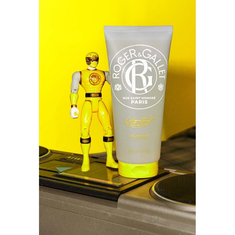 Graue Tube mit gelbem Verschluss. ROGER & GALLET Logo und Schriftzug. Aufschrift: Cologne Twist, Gel Douche, Paris. Gelbe Figur.
