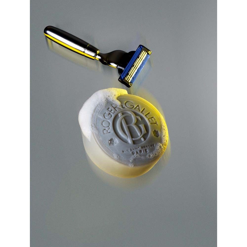 Graue Rasierseife mit Schaum und Rasierer. Auf der Seife steht ROGER & GALLET.