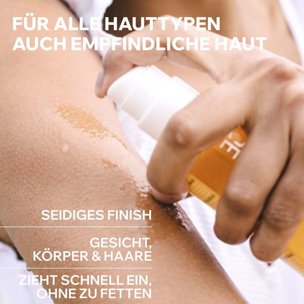 Person sprüht Uriage Bariésun Trockenöl auf Arm. Für alle Hauttypen, auch empfindliche Haut. Seidiges Finish.