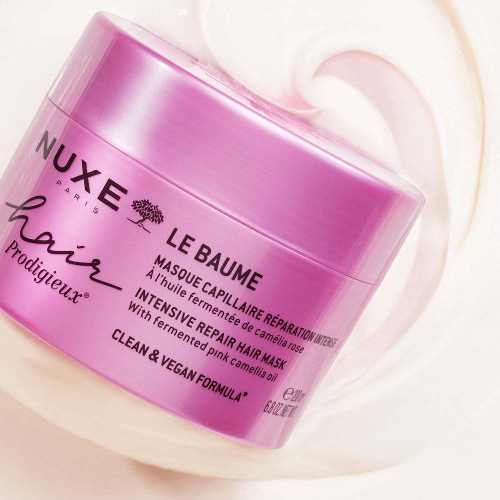 Rosa Dose mit Haarmaske und NUXE-Logo. Creme umgibt die Dose. Text: Intensive Repair Hair Mask.