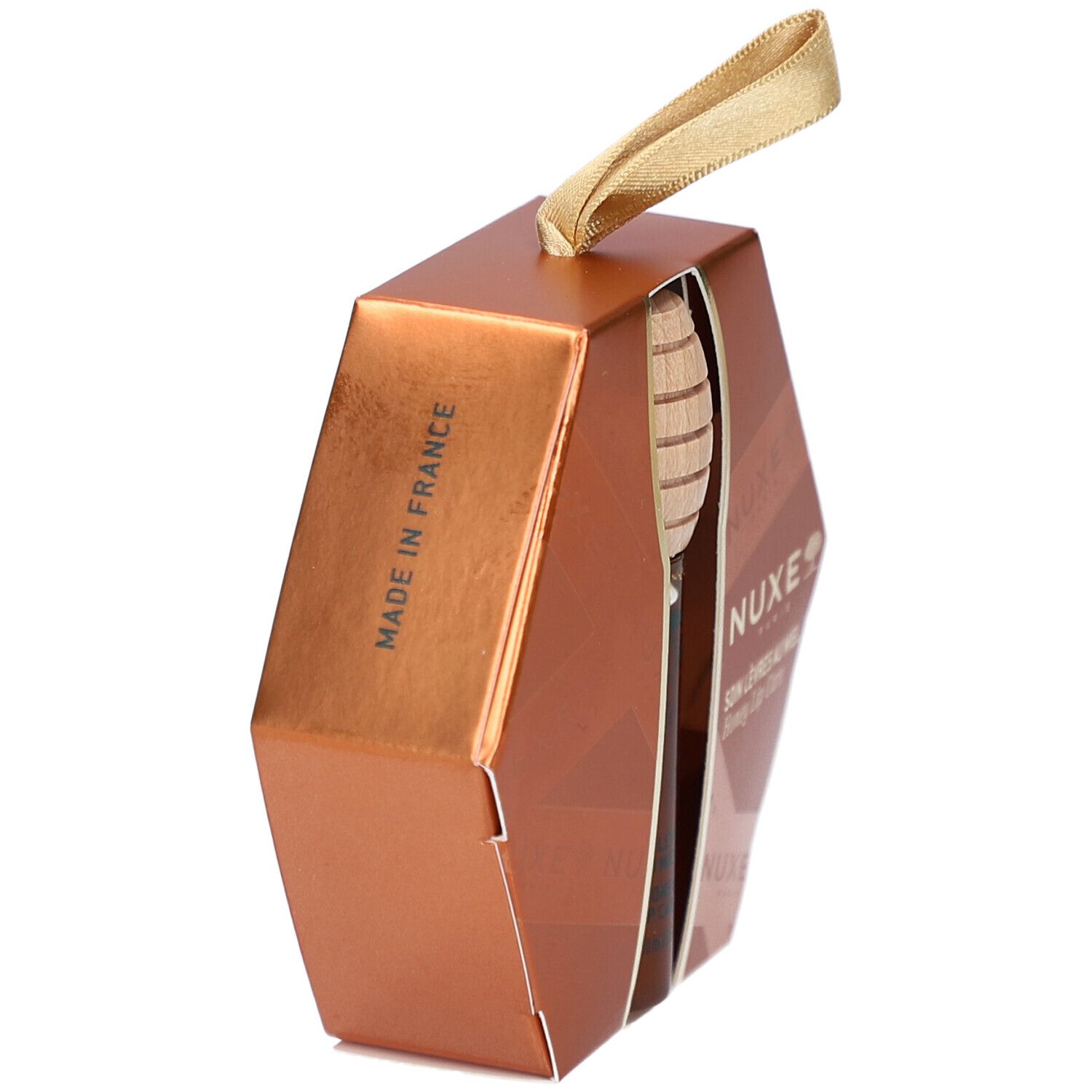 Sechseckige, goldfarbene Verpackung. Aufschrift 'MADE IN FRANCE'. Honiglöffel und Produkt teilweise sichtbar.