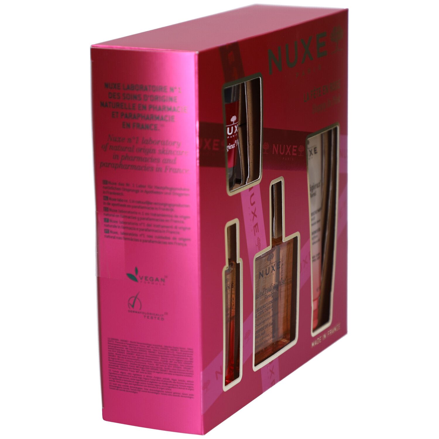 Pinke Geschenkbox, Seitenansicht. Text in mehreren Sprachen, darunter Deutsch und Französisch. Vegan-Logo sichtbar.