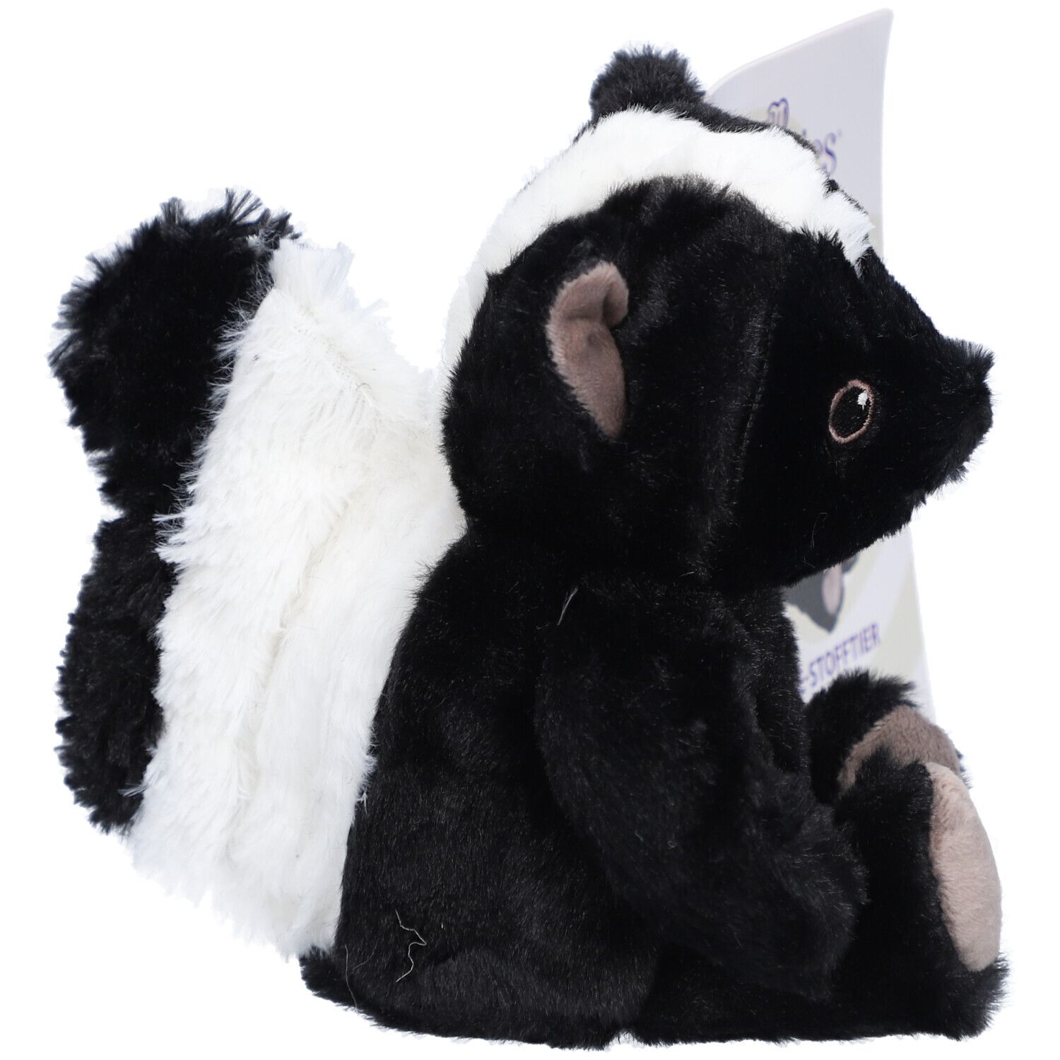 Seitenansicht eines schwarzen und weißen Stofftier-Stinktiers. Ein Etikett ist im Hintergrund zu sehen.