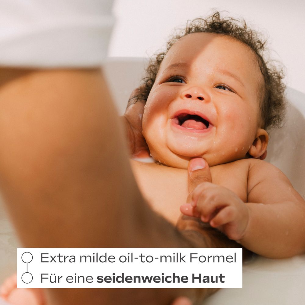 Baby im Bad, lacht. Text: Extra milde oil-to-milk Formel. Für eine seidenweiche Haut.