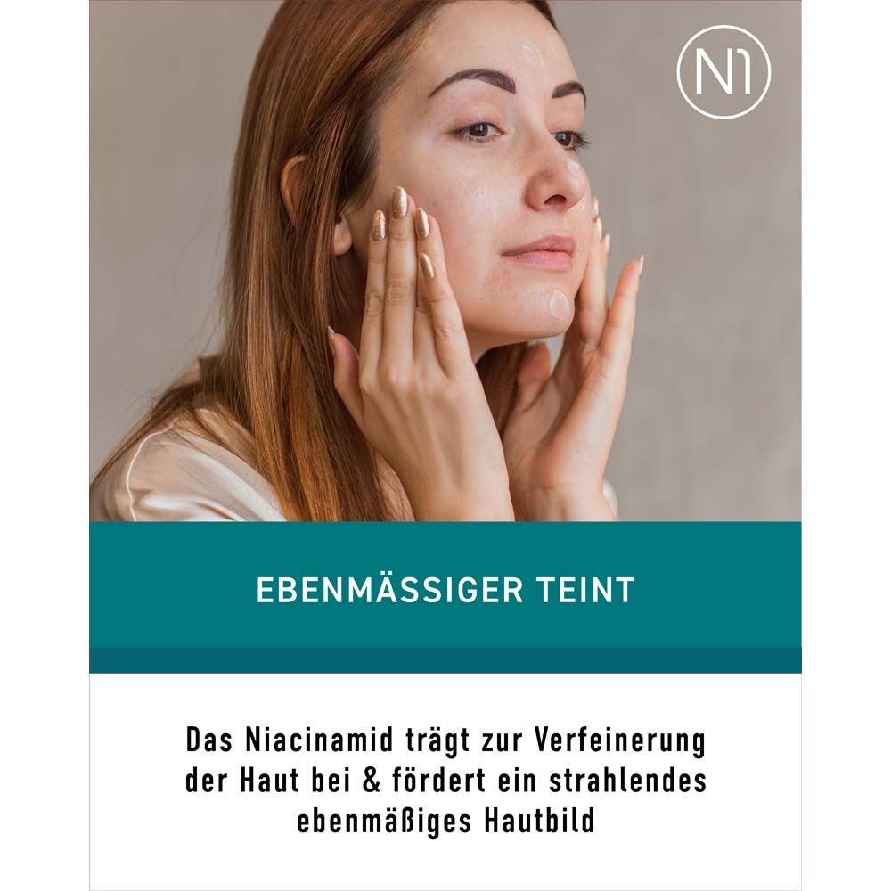 Frau trägt Creme auf. Text: Ebenmäßiger Teint. Niacinamid trägt zur Verfeinerung der Haut bei & fördert ein ebenmäßiges Hautbild.