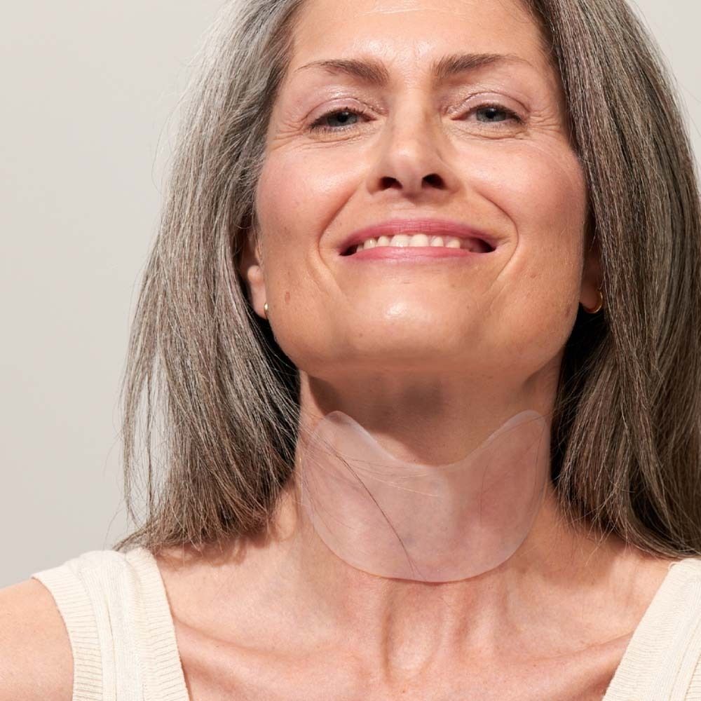 Frau mit Neck Pad am Hals. Das Pad ist transparent und bedeckt den Halsbereich.
