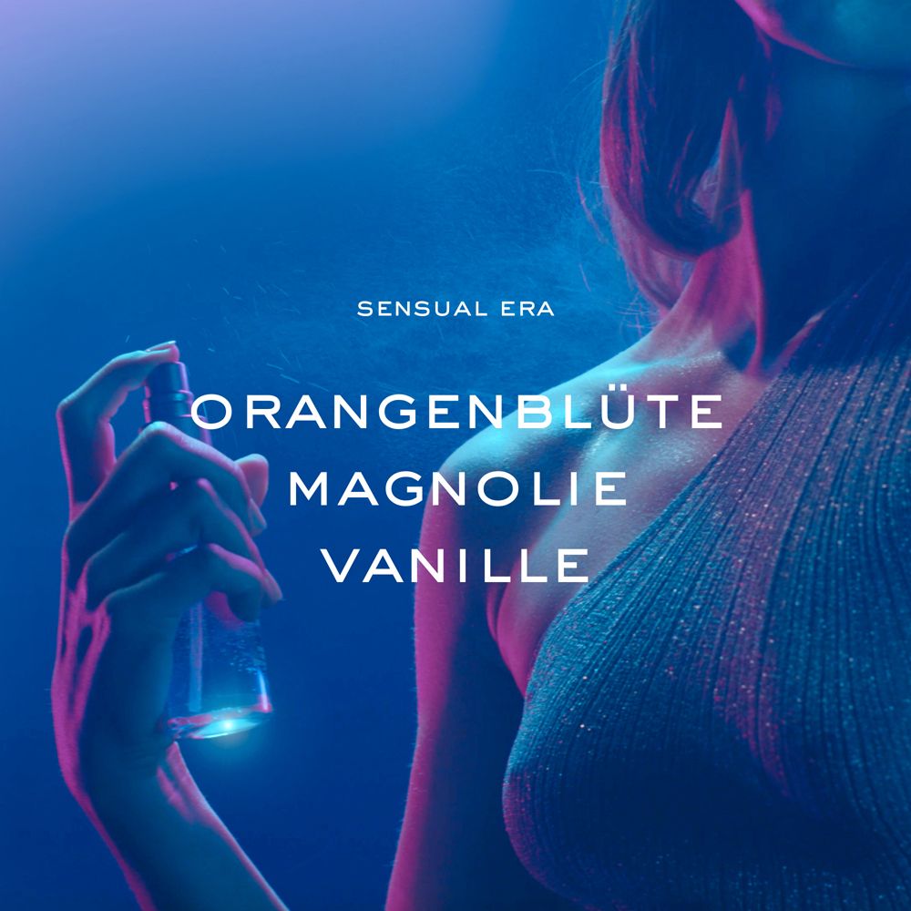 Person sprüht. Text: Sensual Era, Orangenblüte, Magnolie, Vanille. Blauer Hintergrund.