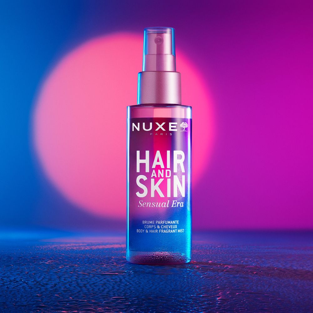 NUXE® Hair and Skin Sensual Era. Rosa Flasche mit Sprühkopf. Text: Hair and Skin, Sensual Era.