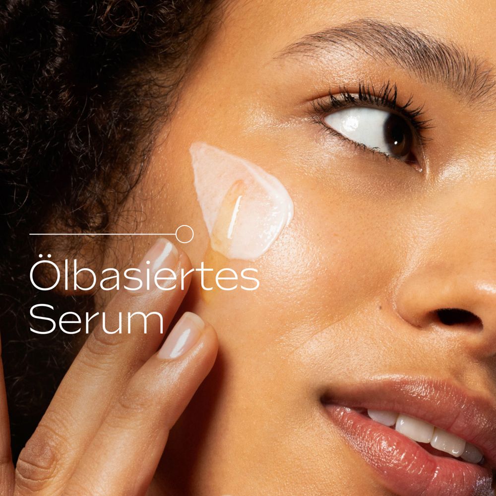 Frau trägt Serum auf. Nahaufnahme. Text: Öl-basiertes Serum.