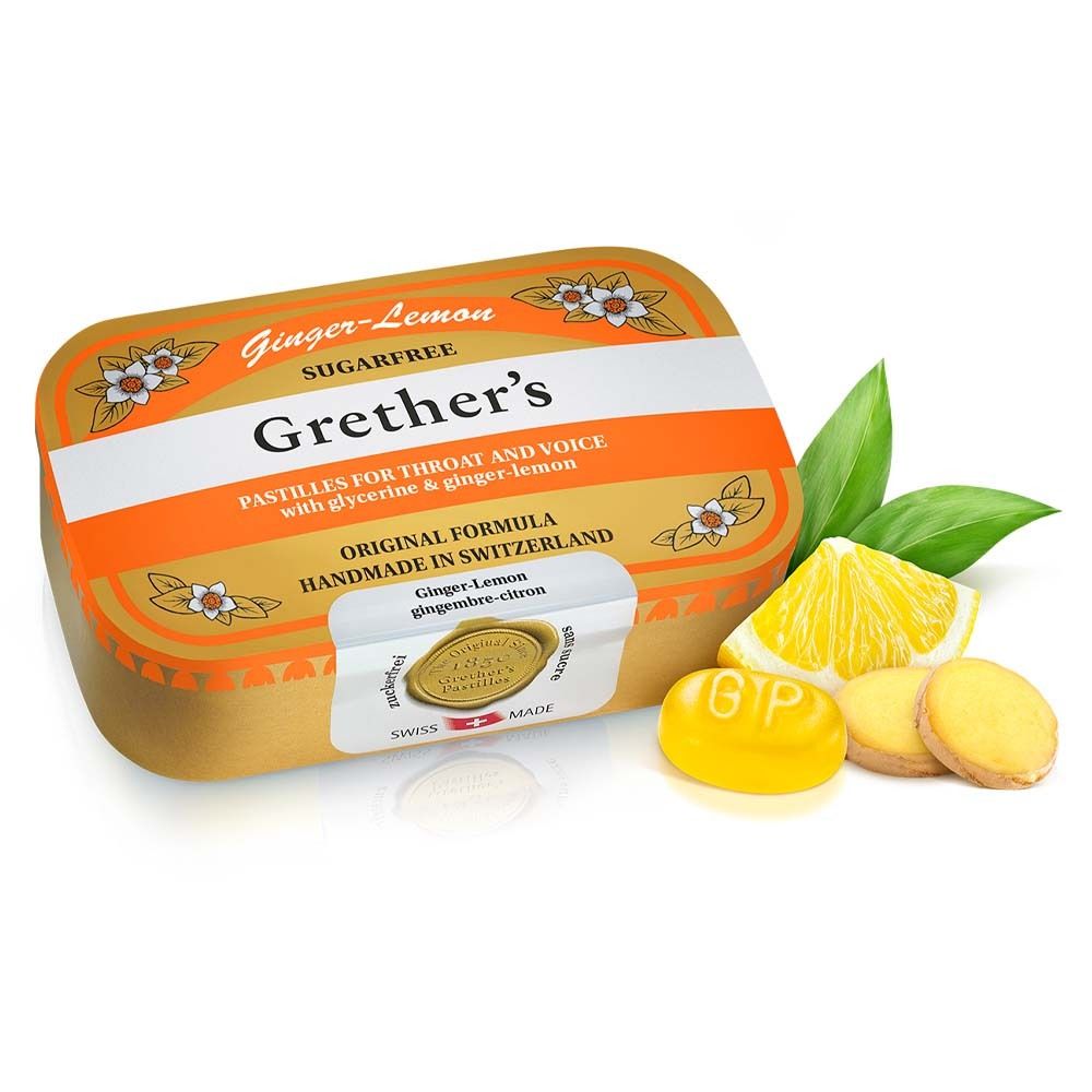 Goldene Dose Grether's Pastilles Ginger Lemon. Zitrone, Ingwer und Pastillen daneben. Schweizer Qualitätssiegel.