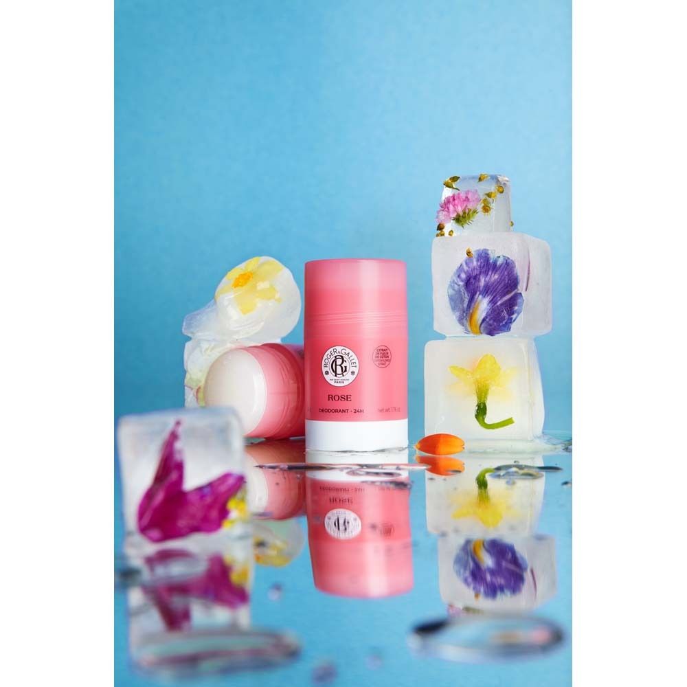 ROGER&GALLET Rose Deodorant-Stick und weitere. Eiswürfel mit Blumen. Reflektierender Untergrund. Blauer Hintergrund.