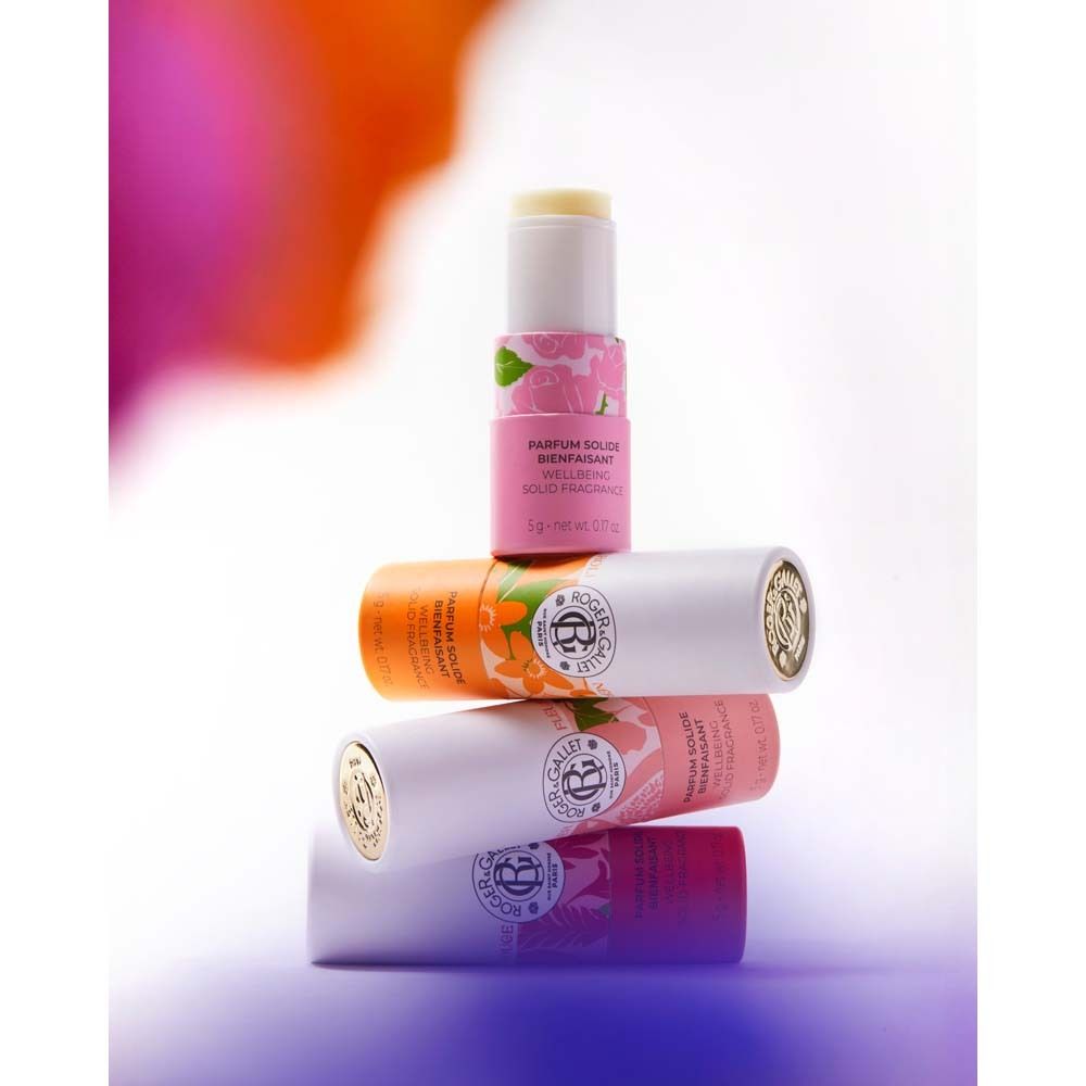Mehrere zylindrische Behälter gestapelt. Aufschrift: ROGER & GALLET, PARFUM SOLIDE BIENFAISANT, WELLBEING SOLID FRAGRANCE. Produkt sichtbar.