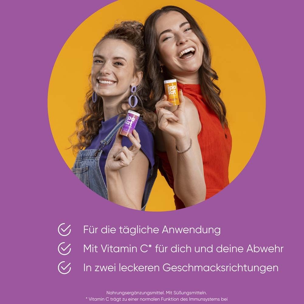 Zwei Frauen halten ipalat®-Dosen. Orange-Ingwer und eine andere Geschmacksrichtung. Lila Hintergrund.