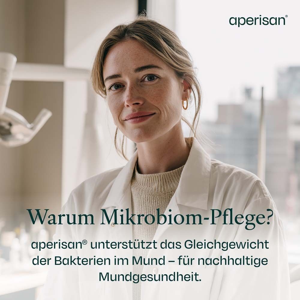 Frau im weißen Kittel. Text: Warum Mikrobiom-Pflege? aperisan® unterstützt das Gleichgewicht der Bakterien im Mund.