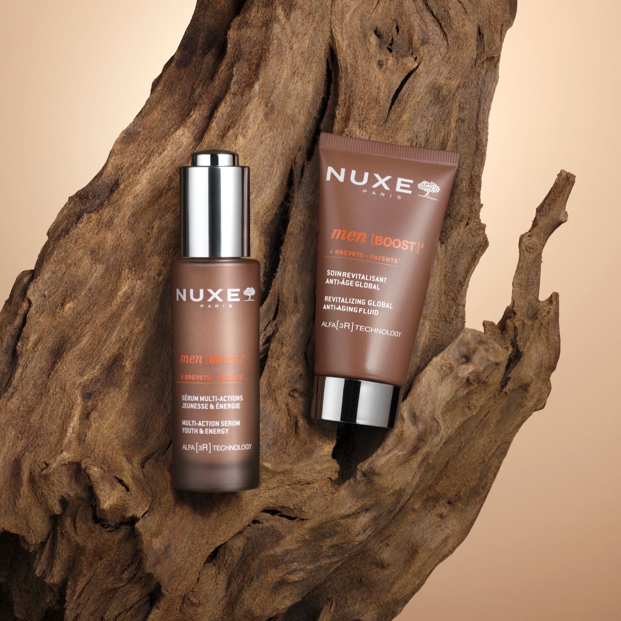 Zwei Produkte auf Holz. Links: Serum. Rechts: Tube. Aufschrift: NUXE PARIS, men [BOOST]³.