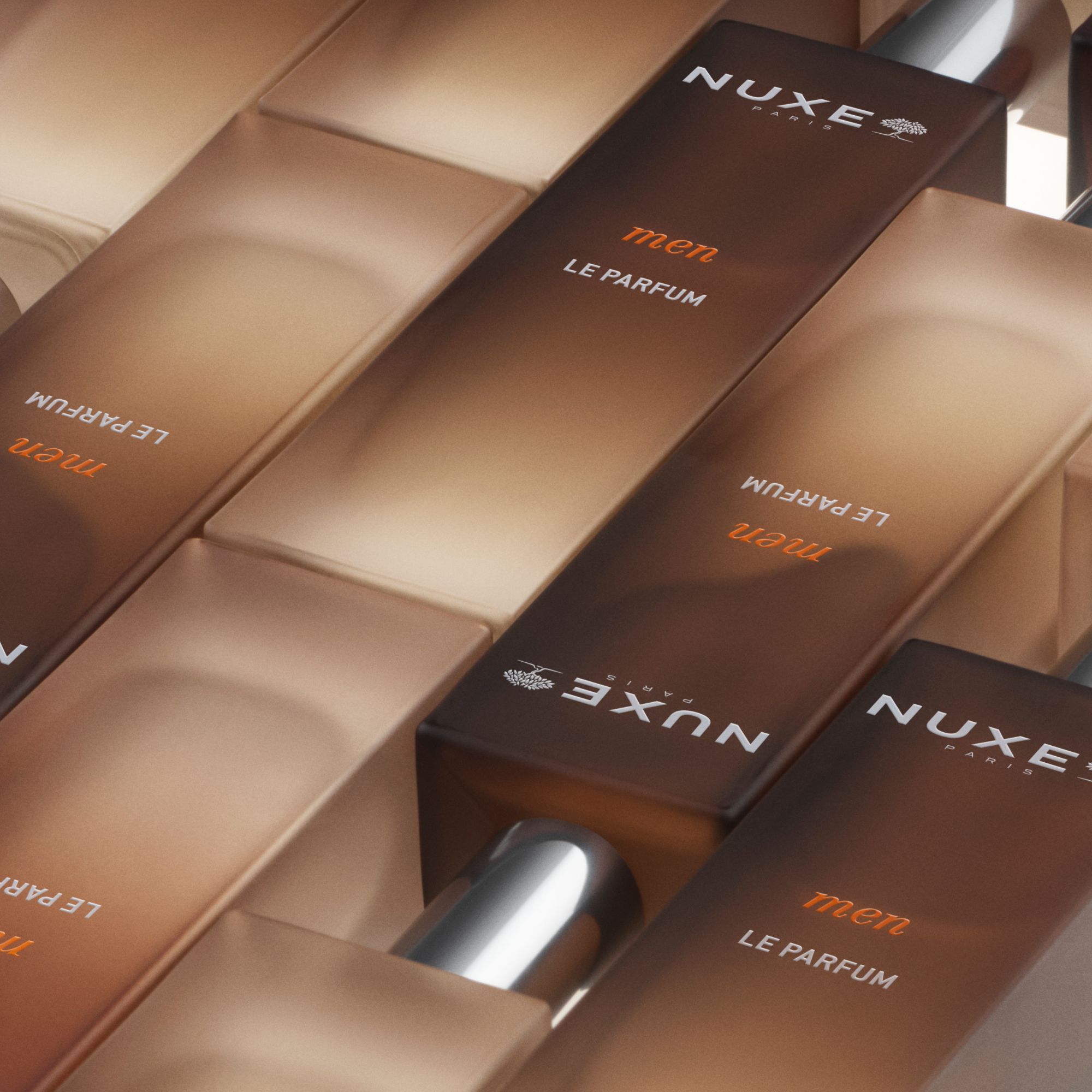 Mehrere Flakons nebeneinander. Aufschrift: NUXE Paris, men, LE PARFUM. Flakons mit silbernen Verschlüssen.