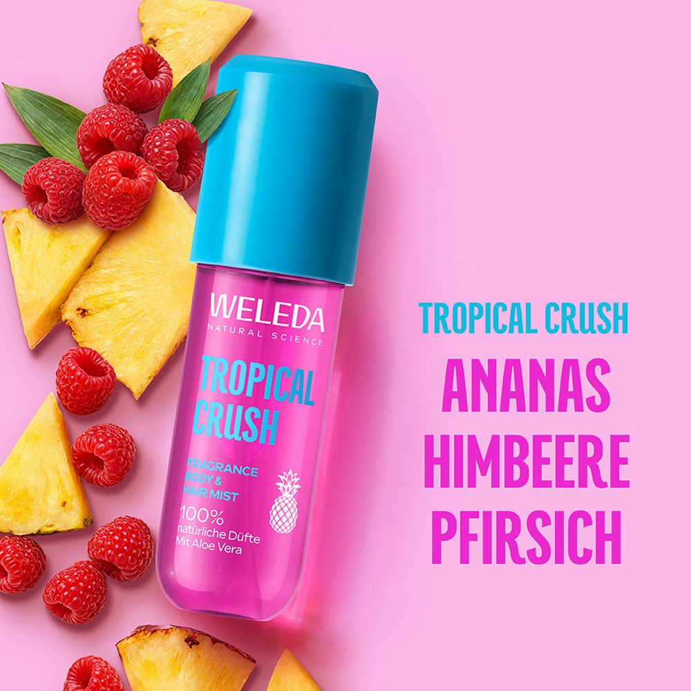 Weleda Tropical Crush Flasche mit Ananas, Himbeeren und Pfirsich. Pinker Hintergrund.