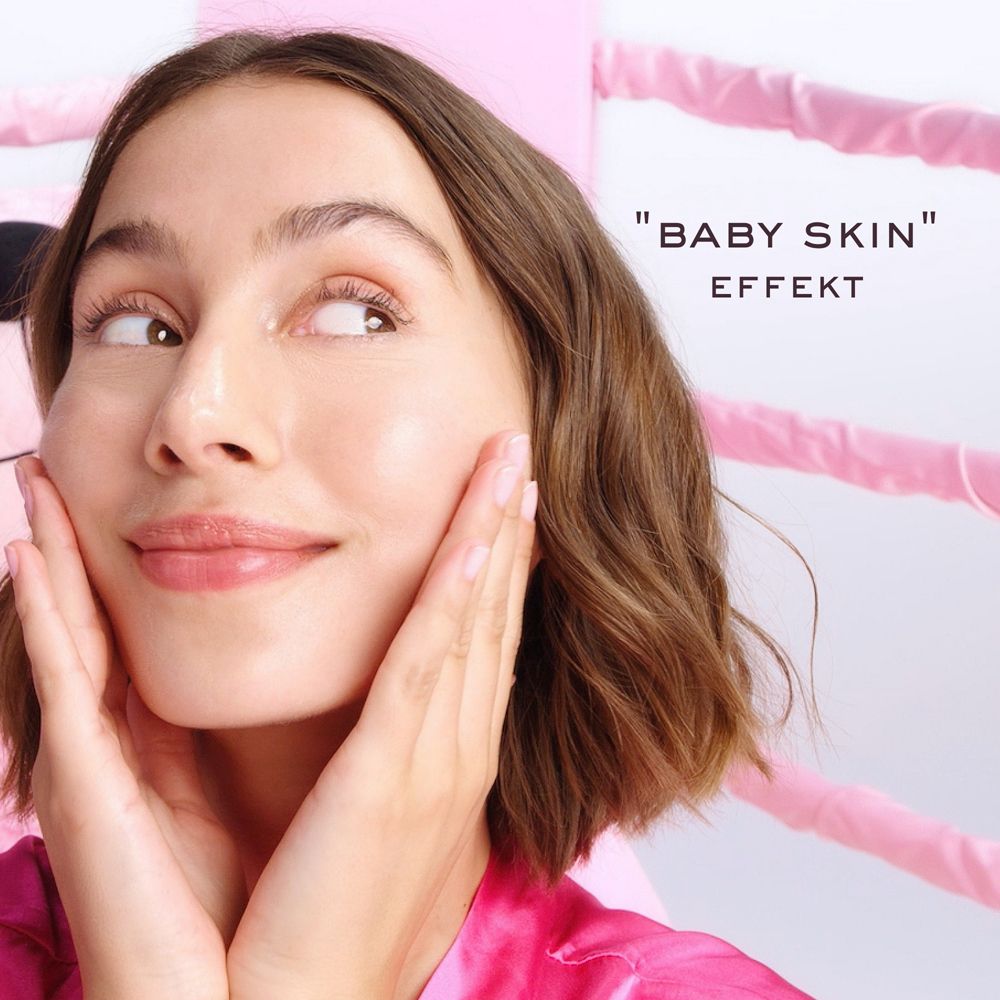 Frau berührt ihr Gesicht. Text: Baby Skin Effekt.