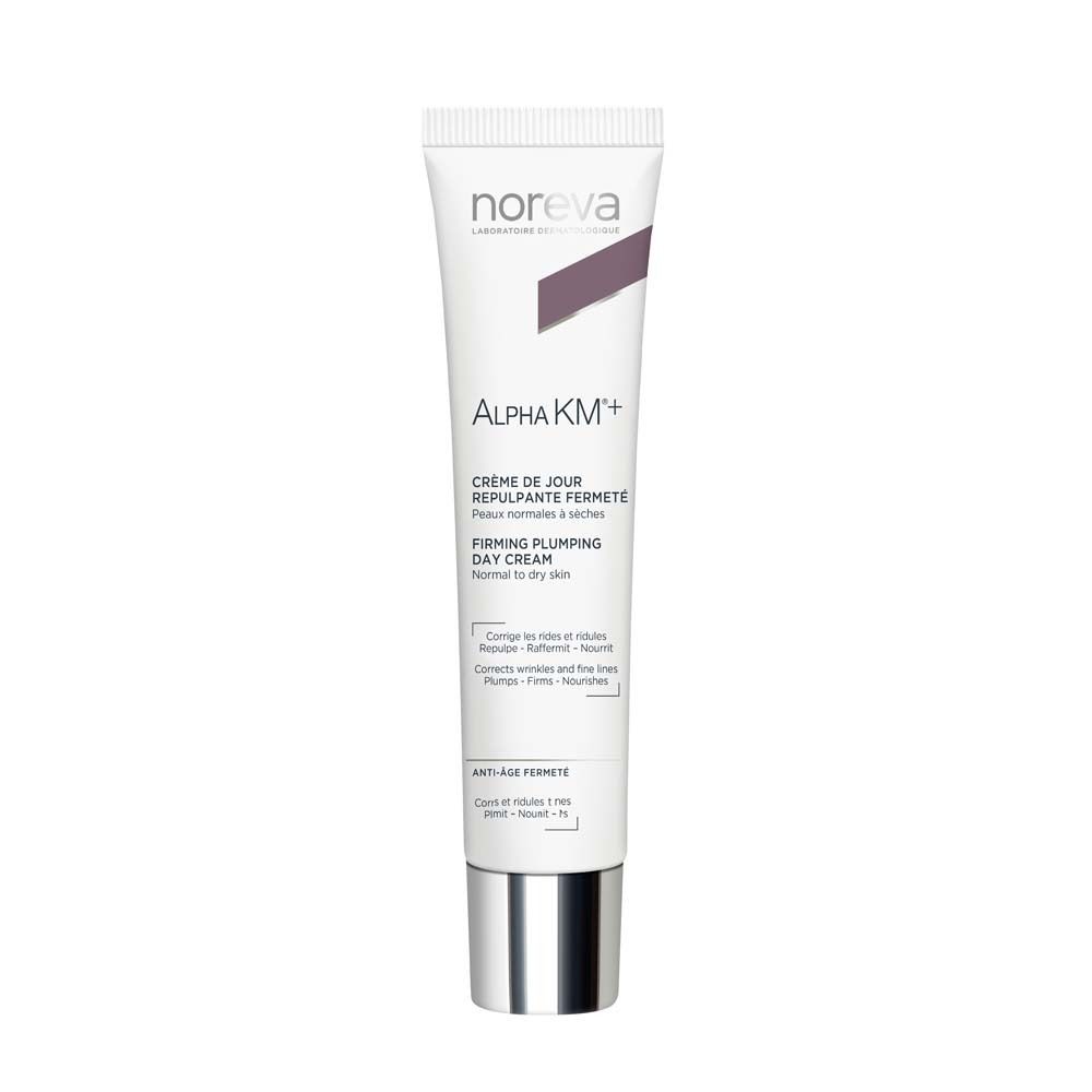 Creme-Tube mit Produktnamen und -bezeichnung. Weiß, silberfarbener Verschluss. Text: Alpha KM+, Crème de Jour, Firming Plumping Day Cream.