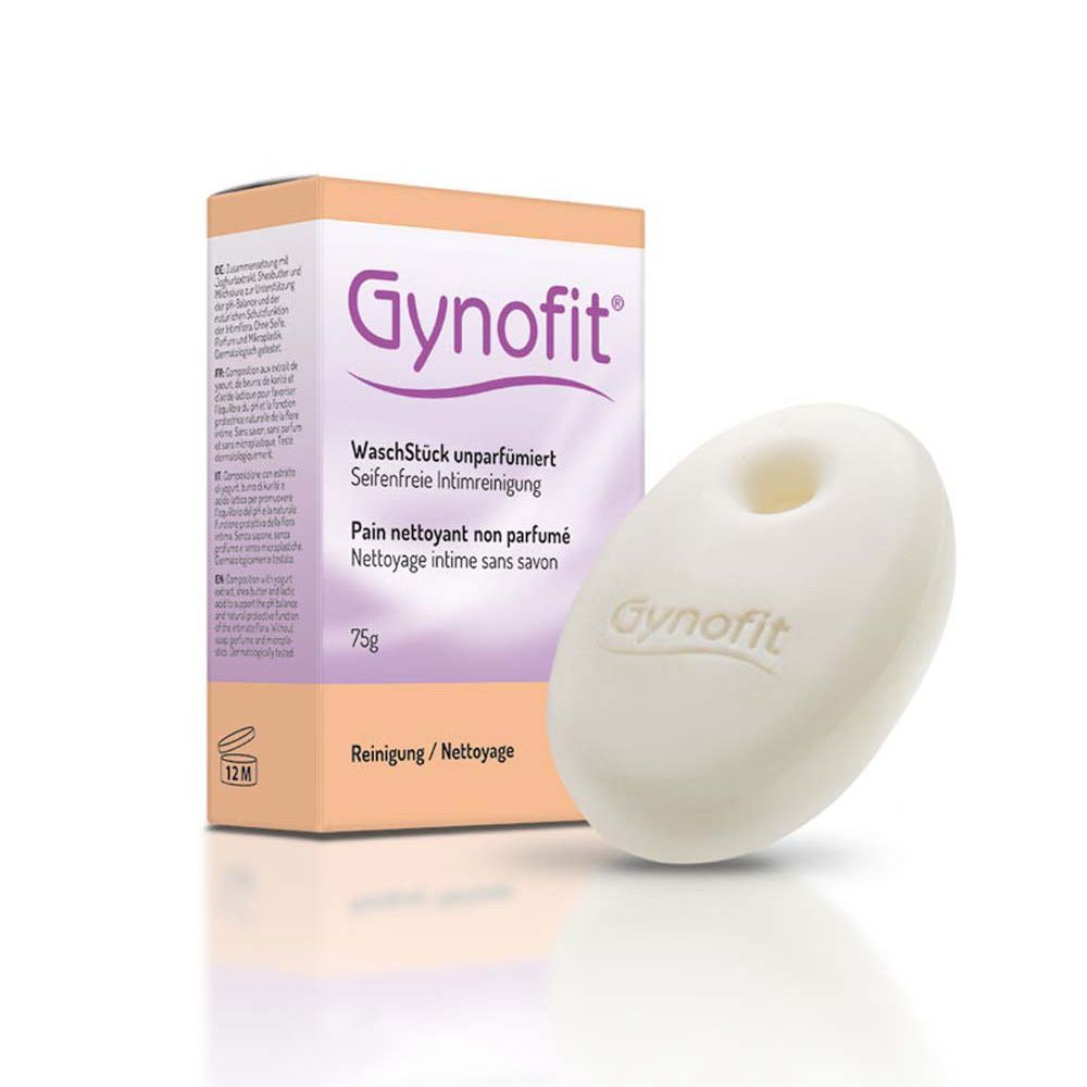 Gynofit Seife und Verpackung. Weiße, ovale Seife mit Loch in der Mitte. Kartonverpackung mit Produktinformationen.