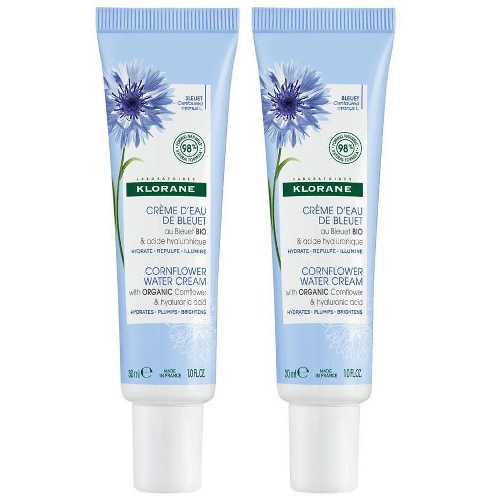 Zwei hellblaue Tuben mit blauer Blume und Text. Enthält Creme d'Eau de Bleuet. 30ml. Mit 98% natürlichen Inhaltsstoffen.