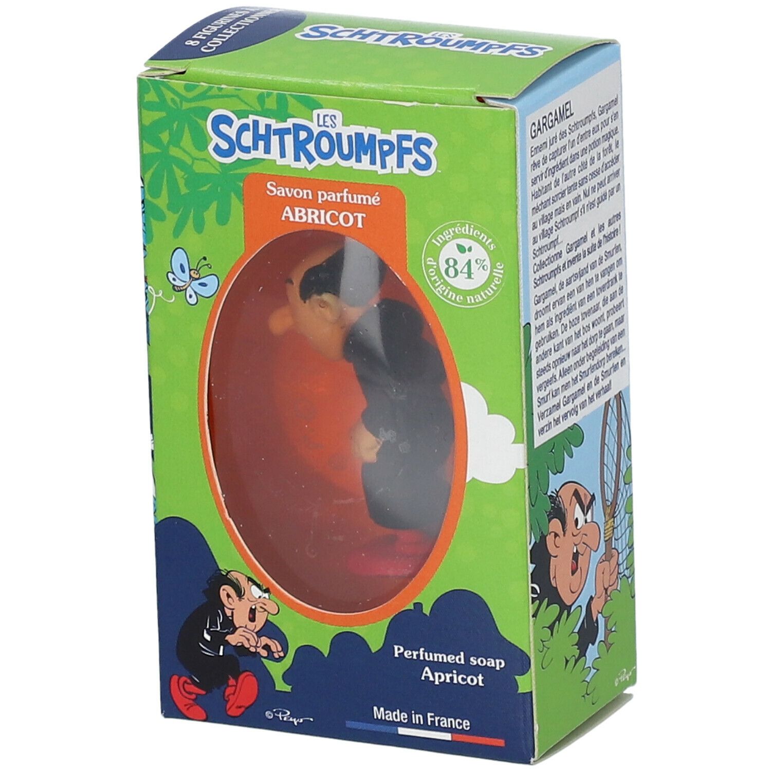 Seife mit Gargamel-Figur in Schachtel. Schachtel mit grünem Hintergrund, Text und Illustrationen. Sichtbares Produkt durch Fenster.