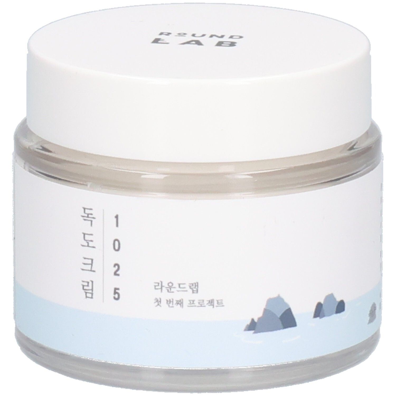 Runde, transparente Dose mit weißem Deckel. Aufkleber mit koreanischem Text und Logo. "ROUND LAB" oben.
