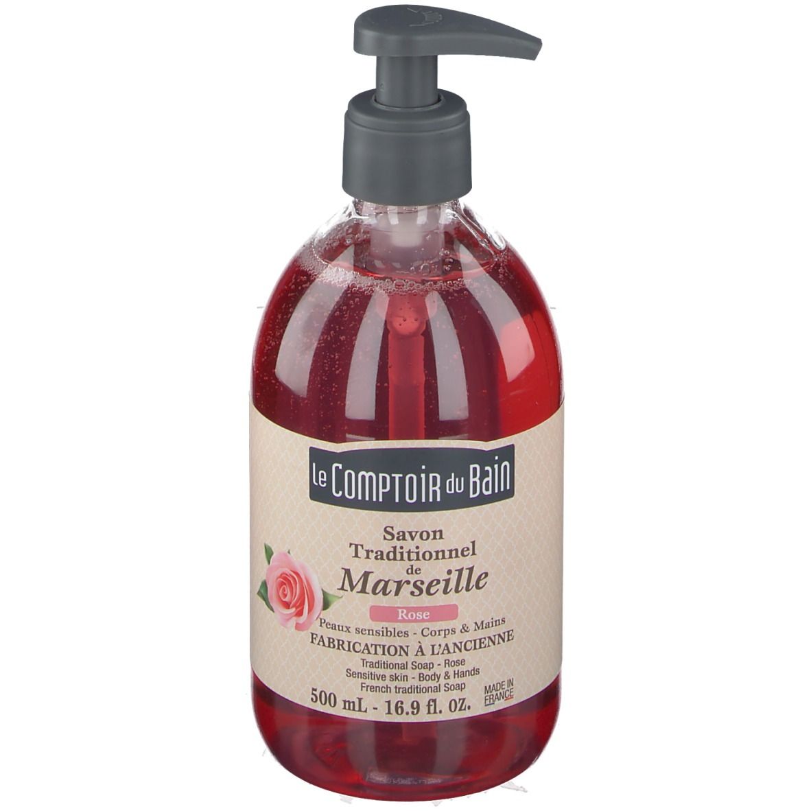 Rote Flüssigseife in einer durchsichtigen Flasche mit Pumpe. Aufschrift: Le Comptoir du Bain, Savon Traditionnel de Marseille Rose.