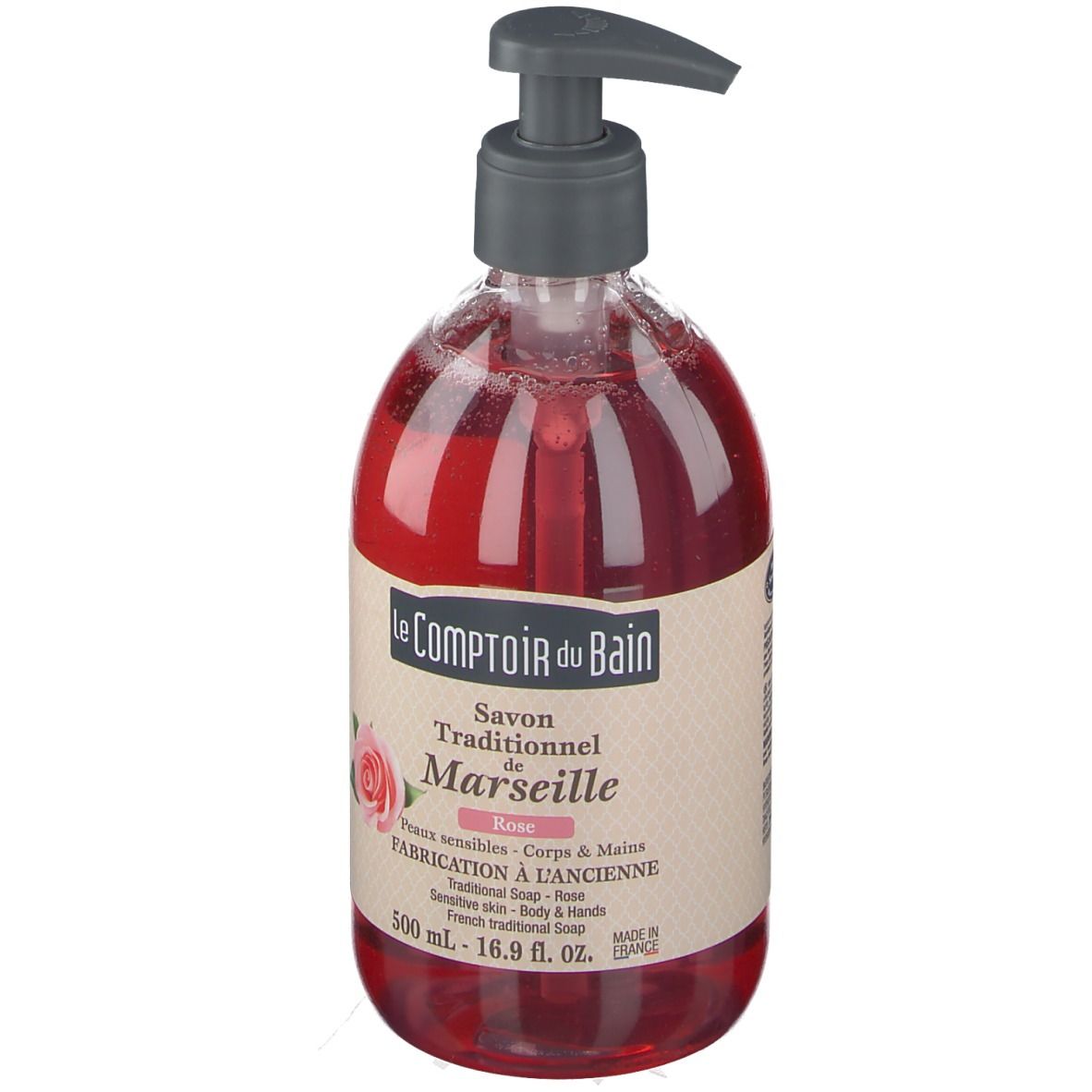 Rote Flüssigseife in einer durchsichtigen Flasche mit Pumpe. Aufschrift: Le Comptoir du Bain, Savon Traditionnel de Marseille Rose.