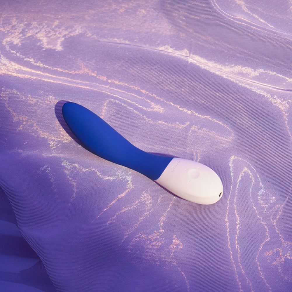 Blau-weißer Vibrator auf lila Stoff. Gebogene Form.