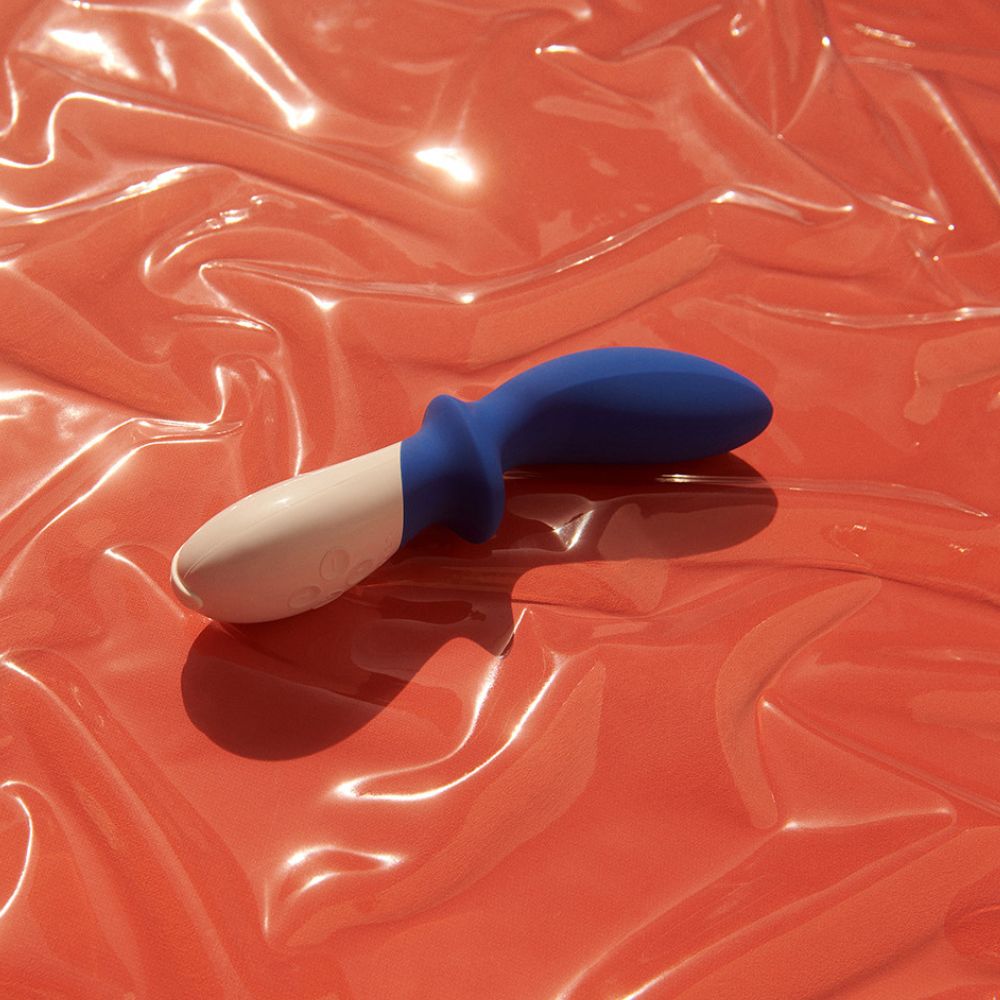 Blau-weißes Wellness-Produkt auf rotem Hintergrund. Ergonomische Form. Silikon.